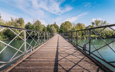 Fototapeta na wymiar Pedestrian bridge crossing River Adda in Italy