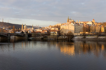 Fototapeta na wymiar Snowy Prague Lesser Town with gothic Castle in the rising sun, Czech republic