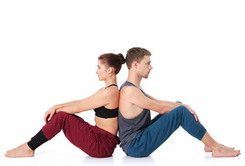 Obraz premium Young athletic couple practicing acroyoga. Balancing in pair
