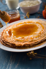 Fresh pancakes with honey, maple syrup, cottage cheese and tangerines. Wooden background. Top view