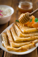 Fresh pancakes with honey, maple syrup, cottage cheese and tangerines. Wooden background. Top view