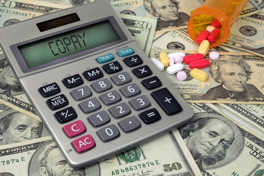 Copay Text On Calculator With Money And Prescription Pills In Bottle