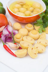 Cut whole champignon mushrooms in brine on white cutting board isolated on white background