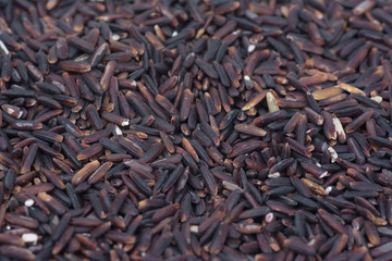 .Raw dark red purple rice (Riceberry) texture pattern background (this kind of rice is originated from a cross-breed between non-glutinous purple rice and white jasmine rice in Thailand