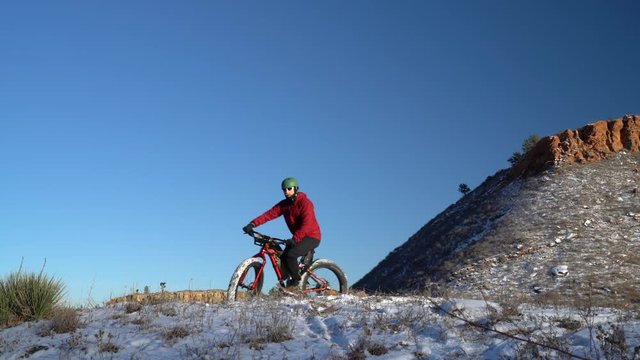 Male cyclist riding a fat mountain bike on a snowy trail in Horsetooth Mountain Park near Fort Collins, Colorado
