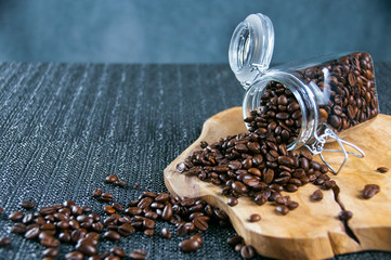 Coffee beans in a crystal jar on a brown wooden backgroundand old gilt metal coffee cup