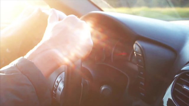 Hands on cabriolet steering wheel, road of the morning