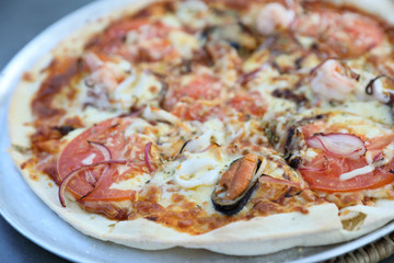 Seafood pizza , with mussel squid shrimp and tomato , italian food