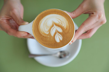 Cappuccino coffee with young woman hand