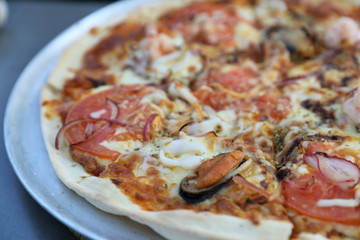 Seafood pizza , with mussel squid shrimp and tomato , italian food