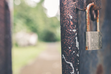 Closeup of a closed rusty padlock on metal door. Balinese temple. Bali island, Indonesia.