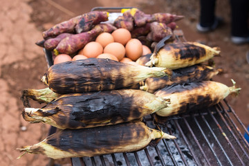 Sweet yam, egg, toast on grill grate traditional cooking (Broiled yam on charcoal broiler) in Thailand.