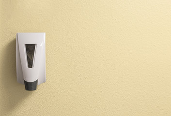 Generic Hand Sanitizer Dispenser on a Textured Cream Wall with Space to Add Writing or Text