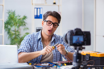 Vlogger recording computer repair on camera for vlog blog
