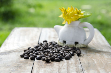 Coffee beans on wood background with ixora flowers