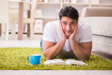 Man reading book at home on floor