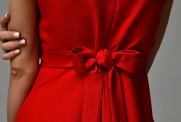 Closeup details of woman red dress bow knot