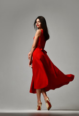 Pretty brunette woman in formal red dress stiletto heels shoes - obrazy, fototapety, plakaty