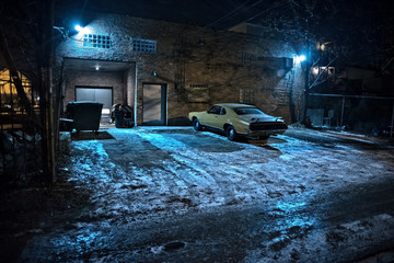 Vintage muscle car in a dark Chicago city urban alley on a winter night.
