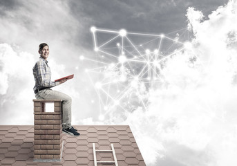 Man on brick roof reading book and concept of social connection