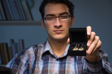 Young male jeweller working at night in his workshop