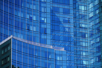 Fototapeta na wymiar close up on modern office building skyscraper with blue glass wall