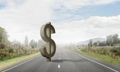 Money making and wealth concept presented by stone dollar symbol on asphalt road