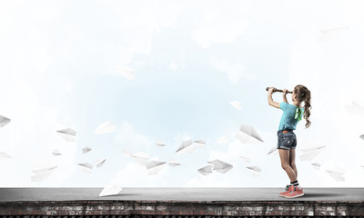 Concept of careless happy childhood with girl exploring this wor