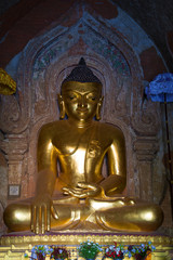 Sculpture of a seated Buddha close-up. The interior of the ancient Buddhist temple Htilominlo Pahto