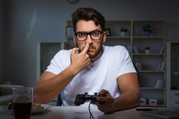 Young man playing games long hours late in the office