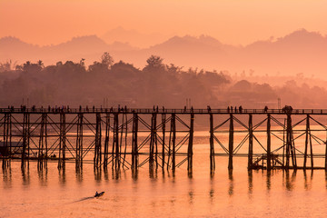 Obraz premium Silhouette old wooden bridge with mountain background and sunlight