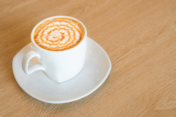 Hot caramel macchiato on wooden table.