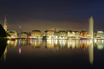 Fototapeta na wymiar Hamburg Binnenalster at night with Alsterhaus and fountain in the background