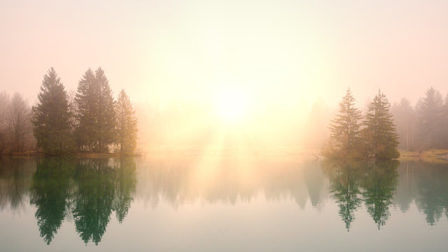 Sunrise at a lake on a foggy morning