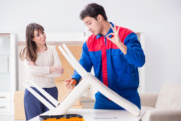 Contractor repairman assembling furniture under woman supervisio
