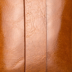Fototapeta premium Luxurious light brown shiny leather with highlights, gradients and seams closeup