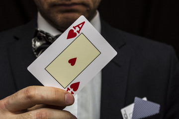 Man with playing cards in suit with bow tie