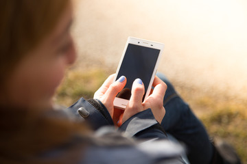 Junge hübsche Frau mit Smartphone in den Händen, Sonnenschein