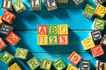 Close up arrangement of "ABC" alphabet on blue background. Preschool, education concept or other your content. Long shadow and vignette effect.