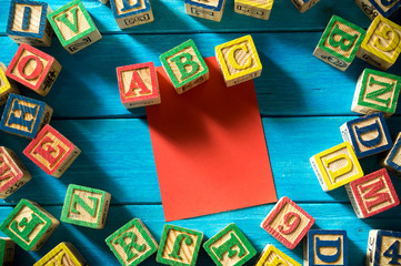 Close up arrangement of alphabet with sticky notes on blue background. Preschool, education concept or other your content. Long shadow and vignette effect.