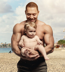 Athletic father with daughter on the beach