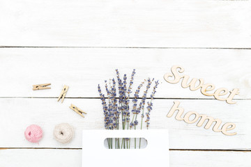 Abouquet of lavender in a paper bag and a wooden inscription sweet home. Flat lay