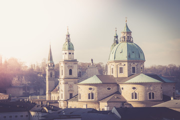 Obraz premium Salzburg stare miasto, scena z zachodem słońca i wieżami kościoła