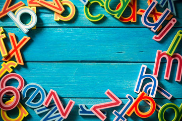 Close up arrangement of alphabet on blue background. Copy-space, preschool, education concept or other your content. Long shadow and vignette effect.