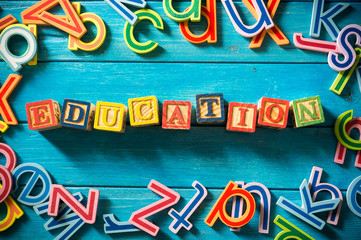 Close up arrangement of "Education" alphabet on blue background. Preschool, education concept or other your content. Long shadow and vignette effect.