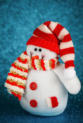 Snowman toy on blue background.
