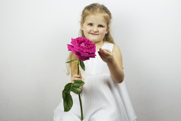 Happy girl in white dress holding a rose