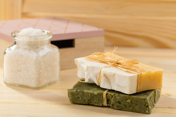 Natural organic soap with toiletries in bathroom on wooden background