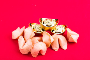 Fortune cookies with decorative gold nuggets on red background
