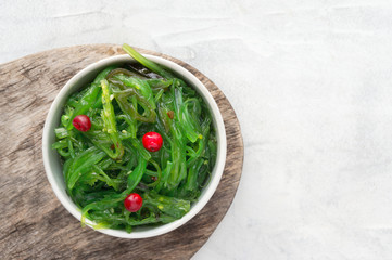 Wakame seaweed marinated in sesame vinaigrette with red berries. Top view. 